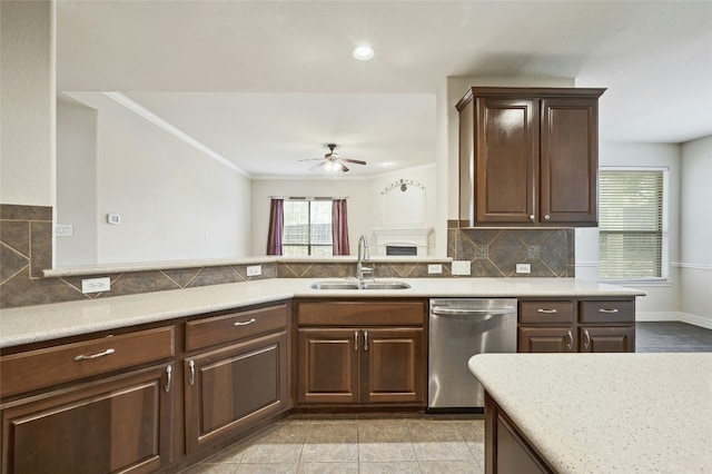 kitchen featuring tasteful backsplash, a ceiling fan, crown molding, stainless steel dishwasher, and a sink