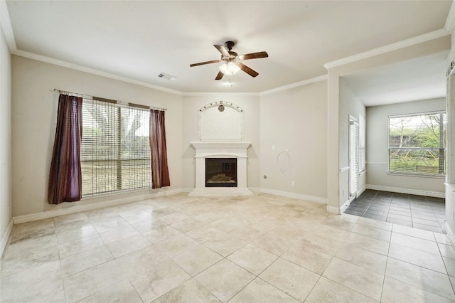 unfurnished living room with ceiling fan, light tile patterned flooring, baseboards, a glass covered fireplace, and crown molding