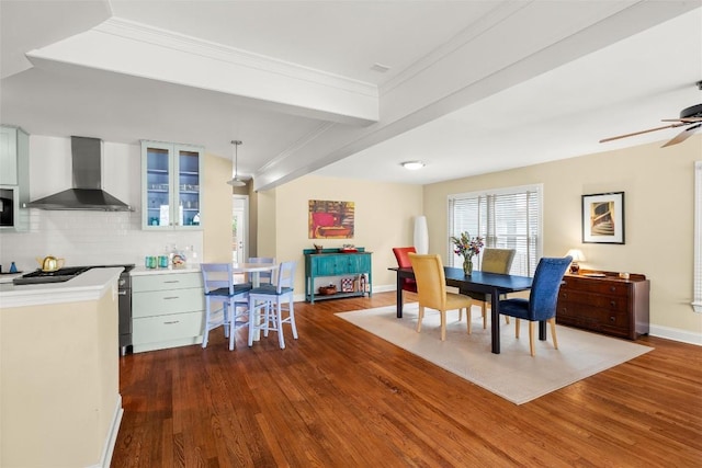 dining room with baseboards, ornamental molding, and dark wood-style floors