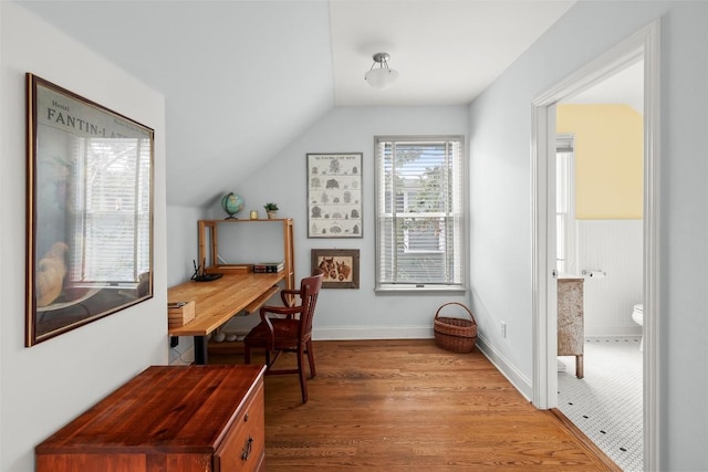 home office featuring lofted ceiling, wood finished floors, and baseboards