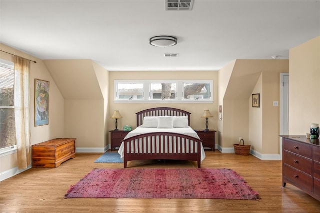 bedroom with baseboards, visible vents, and light wood-style floors