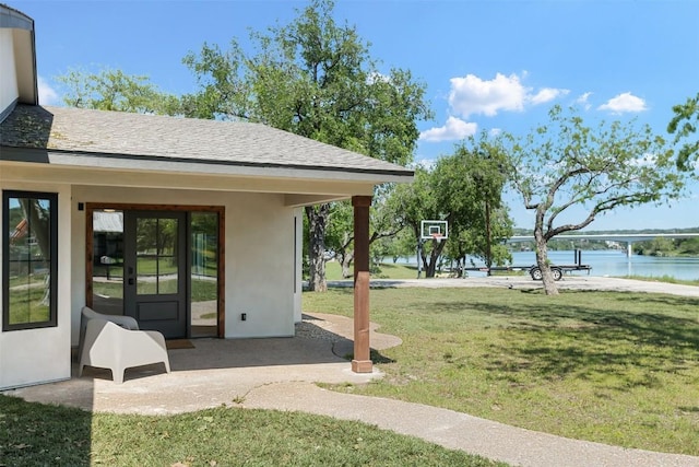 view of yard featuring french doors and a water view