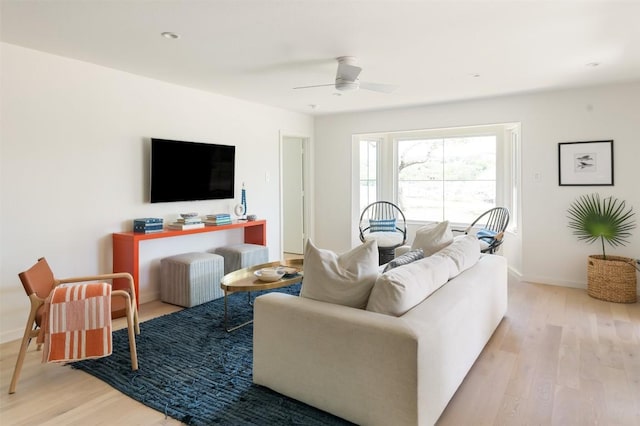 living area with ceiling fan, baseboards, and wood finished floors