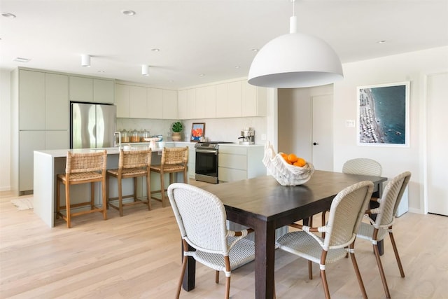 dining space with recessed lighting and light wood finished floors