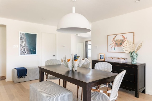 dining area featuring light wood-type flooring and baseboards