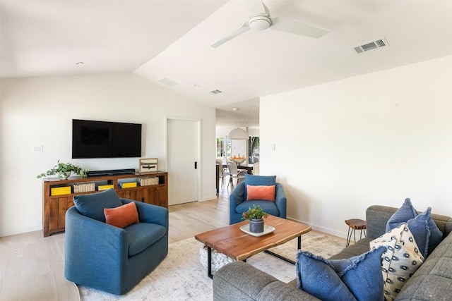 living room featuring light wood-type flooring, ceiling fan, visible vents, and vaulted ceiling