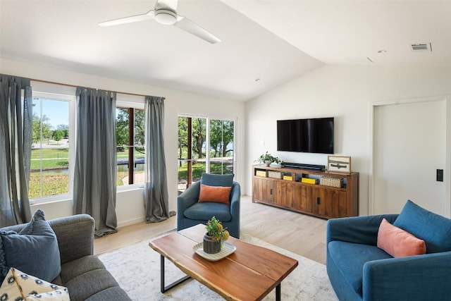 living room with vaulted ceiling, light wood finished floors, visible vents, and a healthy amount of sunlight