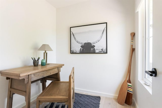 home office with baseboards and wood finished floors