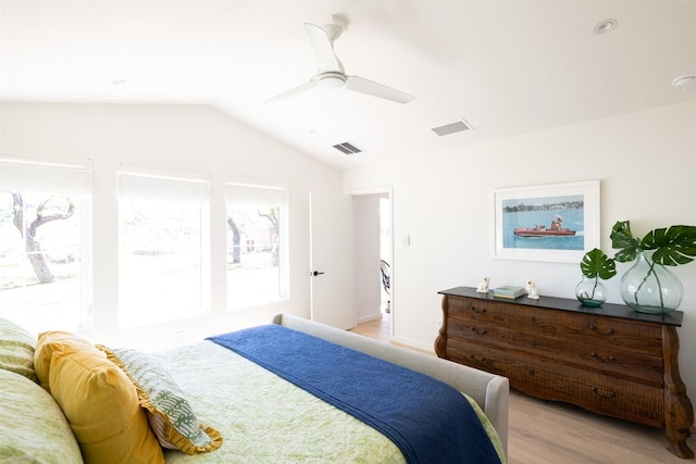 bedroom featuring lofted ceiling, ceiling fan, visible vents, and light wood-style floors