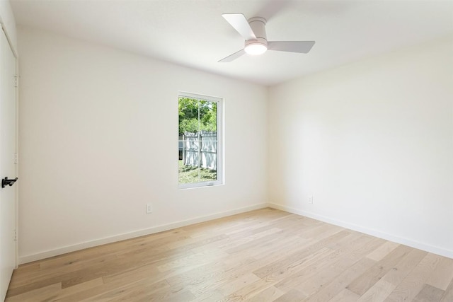 spare room featuring ceiling fan, light wood-type flooring, and baseboards