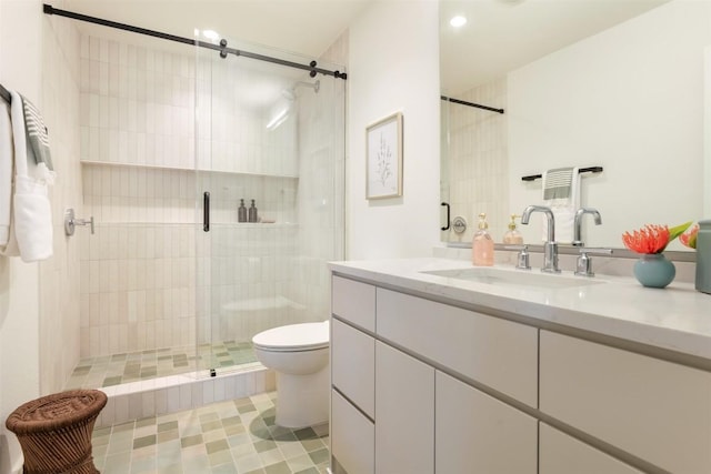 full bath with vanity, a shower stall, and toilet