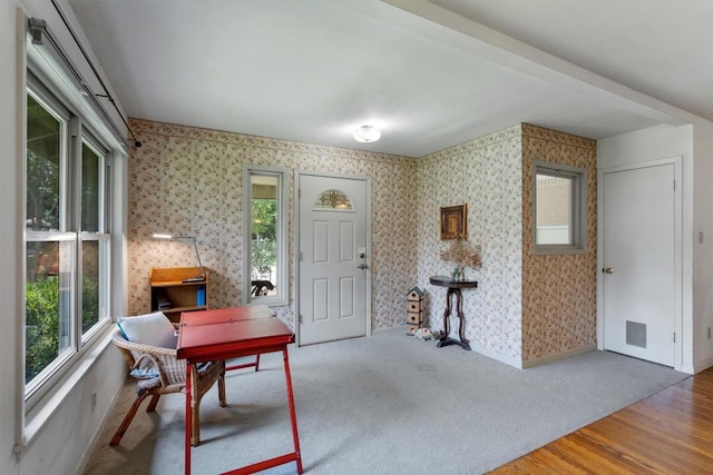 entrance foyer featuring baseboards, wood finished floors, visible vents, and wallpapered walls