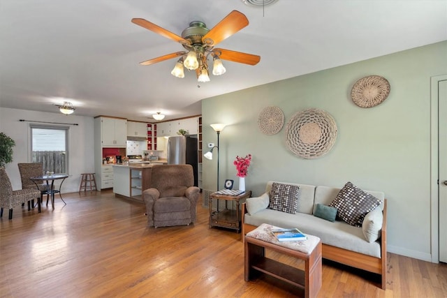 living room with light wood-type flooring and ceiling fan