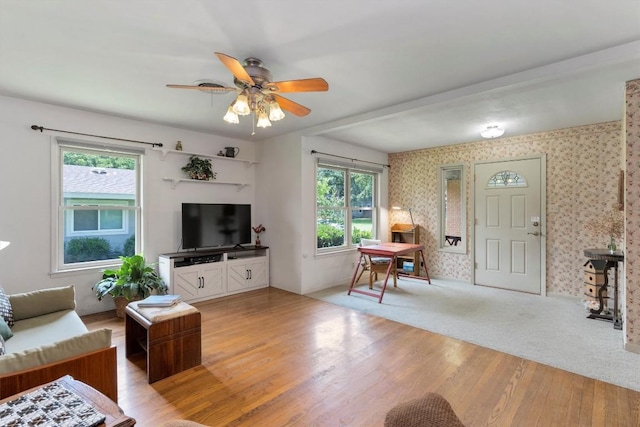 living area with light wood finished floors, a healthy amount of sunlight, and wallpapered walls