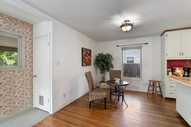 dining space featuring wallpapered walls, plenty of natural light, and dark wood-style flooring