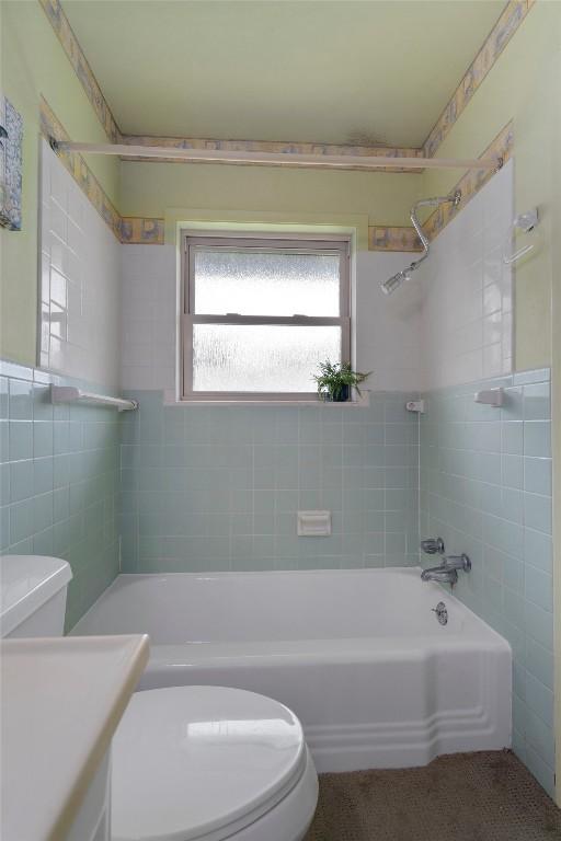 bathroom with bathing tub / shower combination, vanity, and toilet