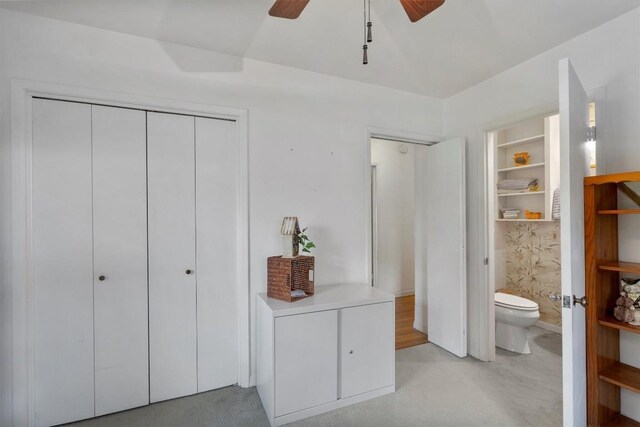 bedroom with connected bathroom, two closets, and a ceiling fan