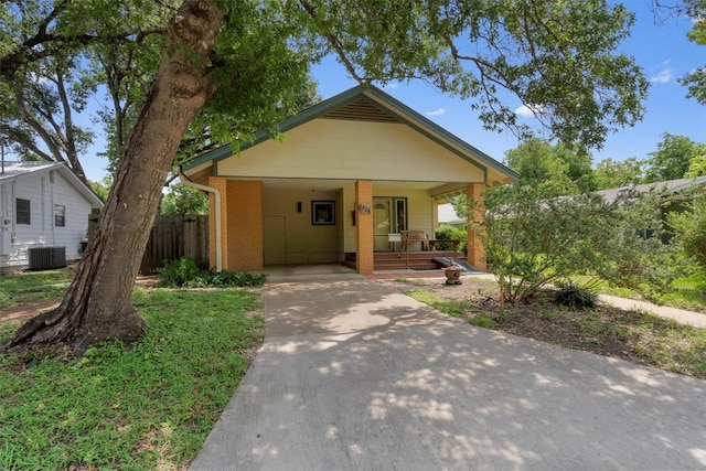 view of front of house with brick siding, a porch, central AC unit, a carport, and driveway