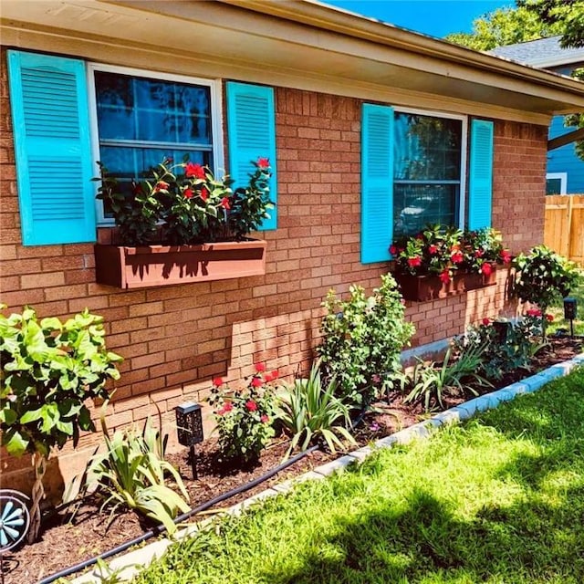 exterior space with fence and brick siding