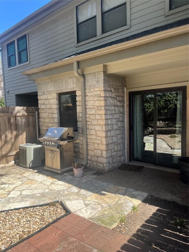 view of patio with a grill, fence, and central AC unit