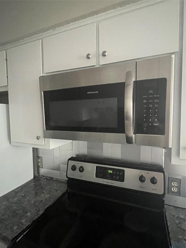 details featuring appliances with stainless steel finishes, white cabinetry, and tasteful backsplash