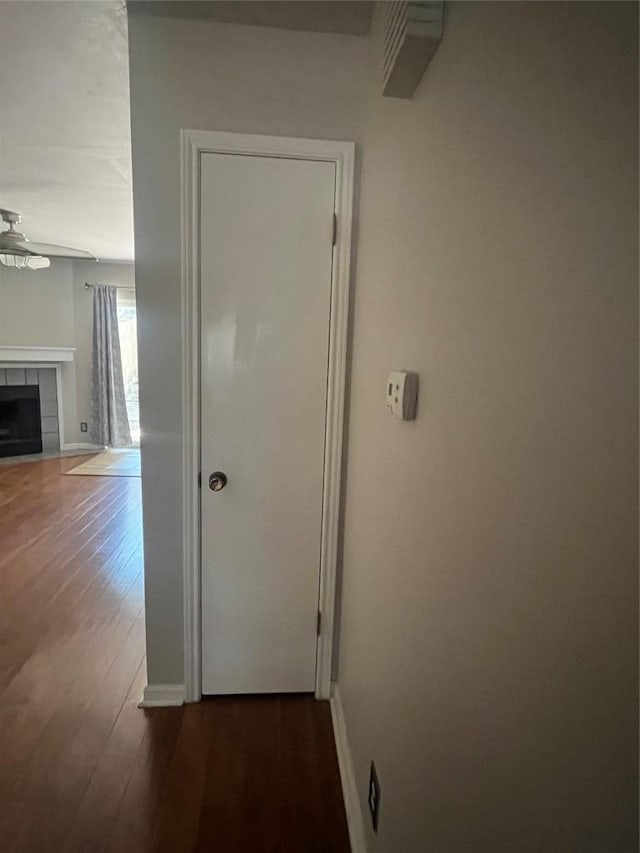 corridor with baseboards and wood finished floors