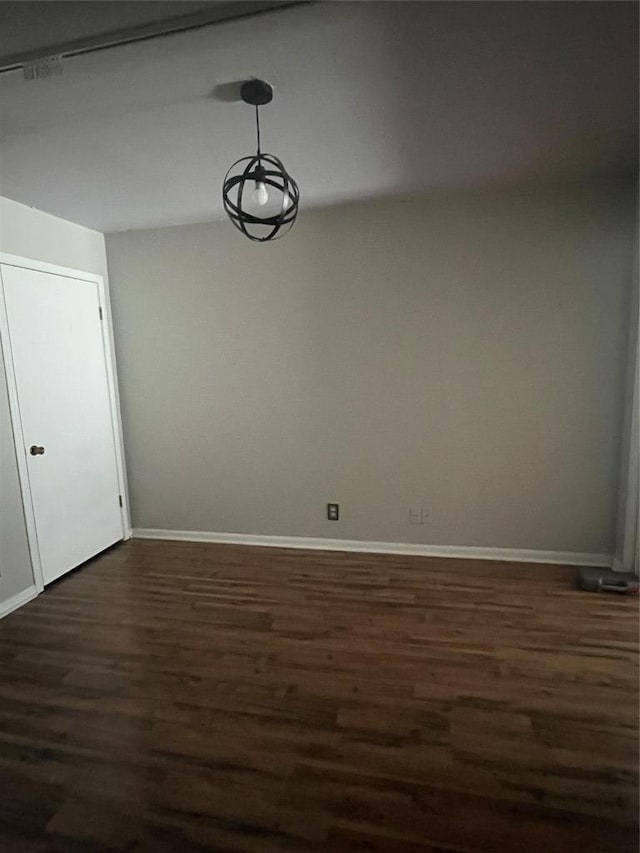 unfurnished dining area with dark wood-style floors and baseboards