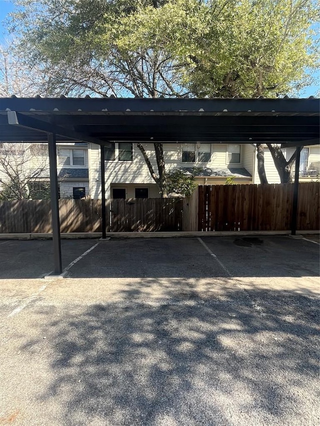 covered parking lot featuring fence