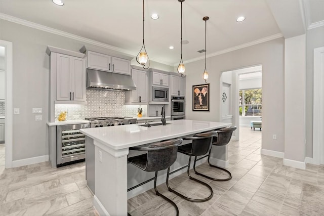 kitchen featuring decorative backsplash, wine cooler, stainless steel appliances, under cabinet range hood, and a sink