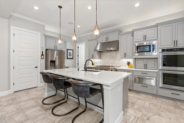 kitchen with under cabinet range hood, gray cabinetry, a sink, appliances with stainless steel finishes, and a warming drawer