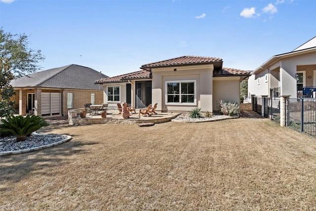 back of property with a patio, a tile roof, fence, a yard, and stucco siding