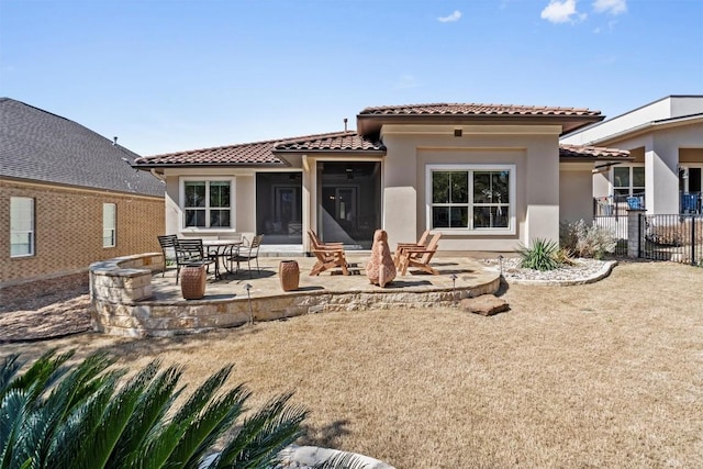 back of property with stucco siding, a tiled roof, fence, and a patio