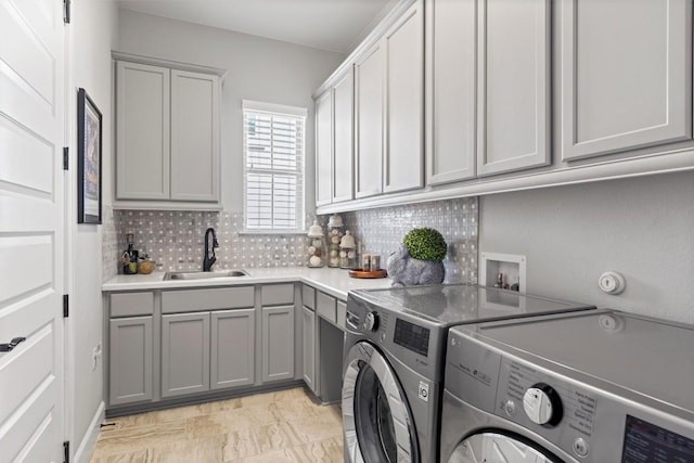 clothes washing area featuring a sink, cabinet space, and washer and dryer