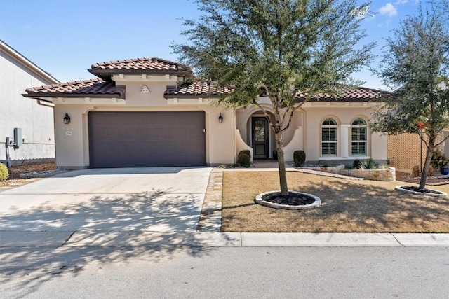 mediterranean / spanish-style house featuring a tiled roof, an attached garage, driveway, and stucco siding