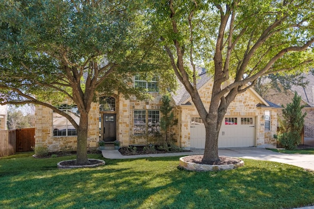 view of front of home featuring driveway, a garage, stone siding, fence, and a front lawn