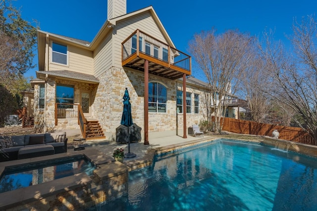 rear view of property with a chimney, fence, a balcony, and a patio