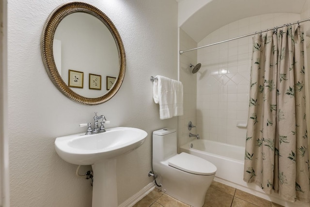 bathroom featuring toilet, shower / bath combo with shower curtain, and tile patterned floors