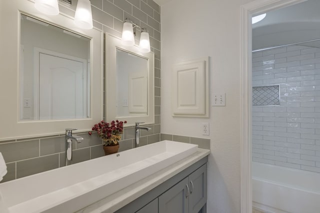 full bath featuring tasteful backsplash, shower / tub combination, tile walls, and vanity