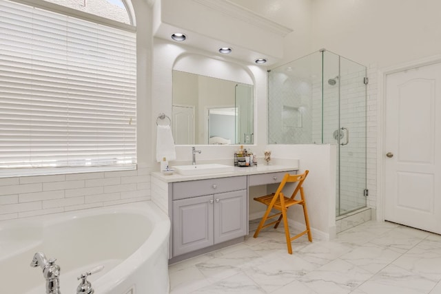 bathroom with a garden tub, marble finish floor, a shower stall, and vanity