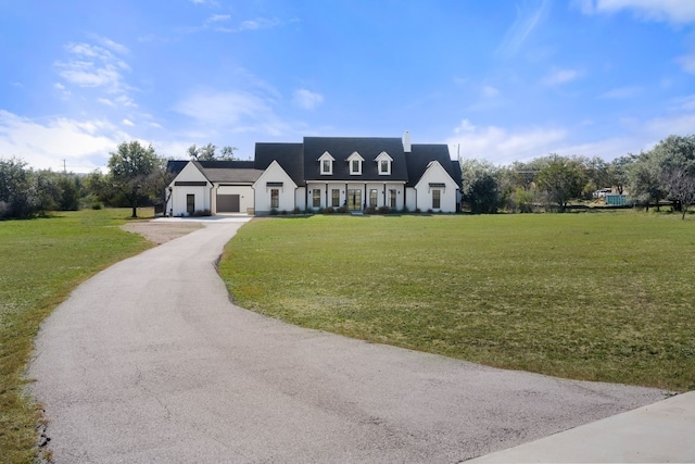 view of front facade featuring a garage, driveway, and a front lawn