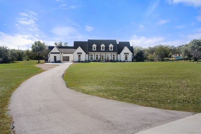 23937 Oscar Rd, Spicewood, TX 78669 - view of front facade with a garage, a front lawn, a chimney, and board and batten siding