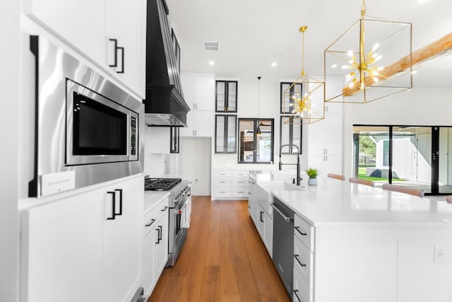 23937 Oscar Rd, Spicewood, TX 78669 - kitchen featuring appliances with stainless steel finishes, custom range hood, a chandelier, a sink, and recessed lighting