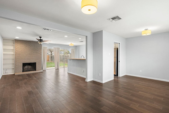 12314 Double Tree Ln, Austin, TX 78750 - unfurnished living room featuring dark wood-style floors, ceiling fan, a brick fireplace, baseboards, and recessed lighting
