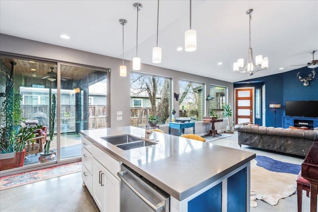 kitchen with ceiling fan with notable chandelier, a sink, white cabinetry, open floor plan, and stainless steel dishwasher