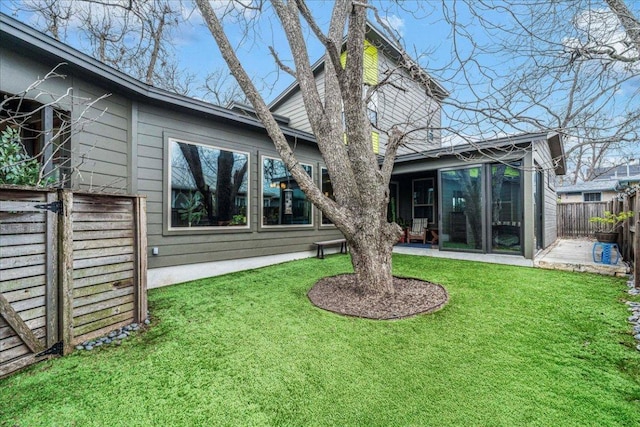 rear view of house featuring a lawn, a patio area, and a fenced backyard