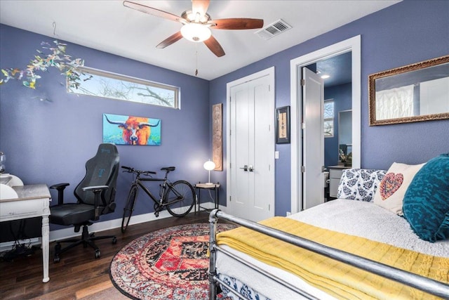 bedroom with baseboards, visible vents, a ceiling fan, wood finished floors, and a closet