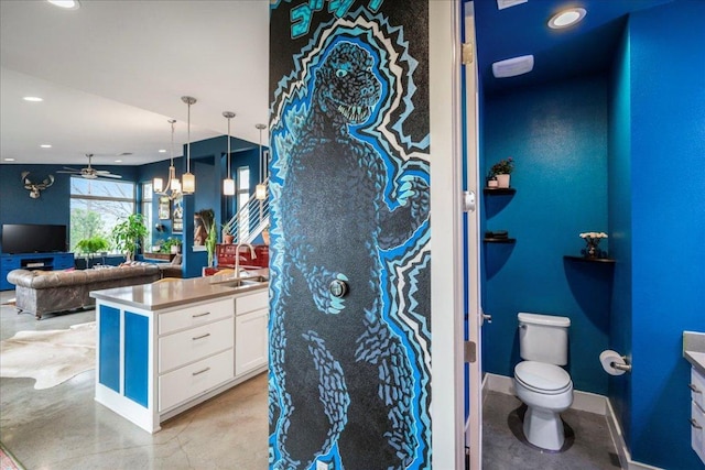 bathroom featuring concrete flooring, toilet, recessed lighting, vanity, and baseboards