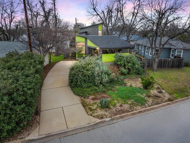 view of front of home featuring a shingled roof and fence