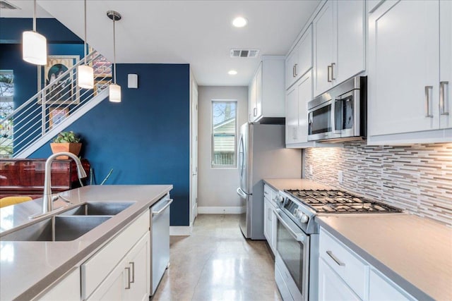 kitchen with tasteful backsplash, visible vents, appliances with stainless steel finishes, white cabinetry, and a sink