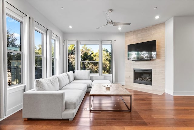 living room featuring wood finished floors, a tile fireplace, and recessed lighting